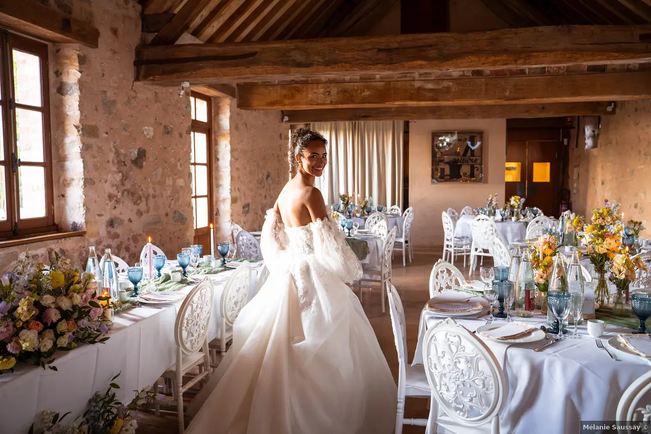 Une mariée qui découvre sa salle de diner et elle sourit et se retourne vers l'objectif