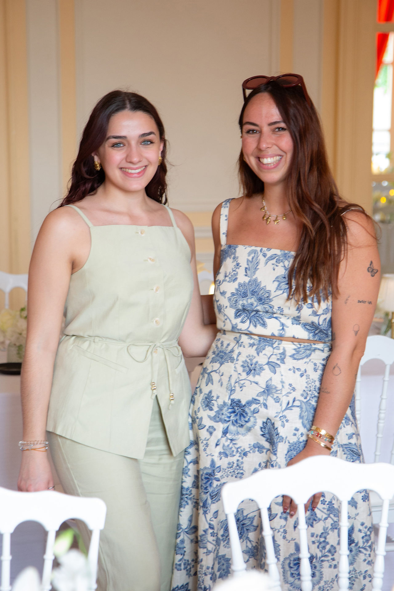 Deux wedding planner prisent en photo dans la salle du diner d'un mariage pendant la préparation, elles prennent la pose et sourient