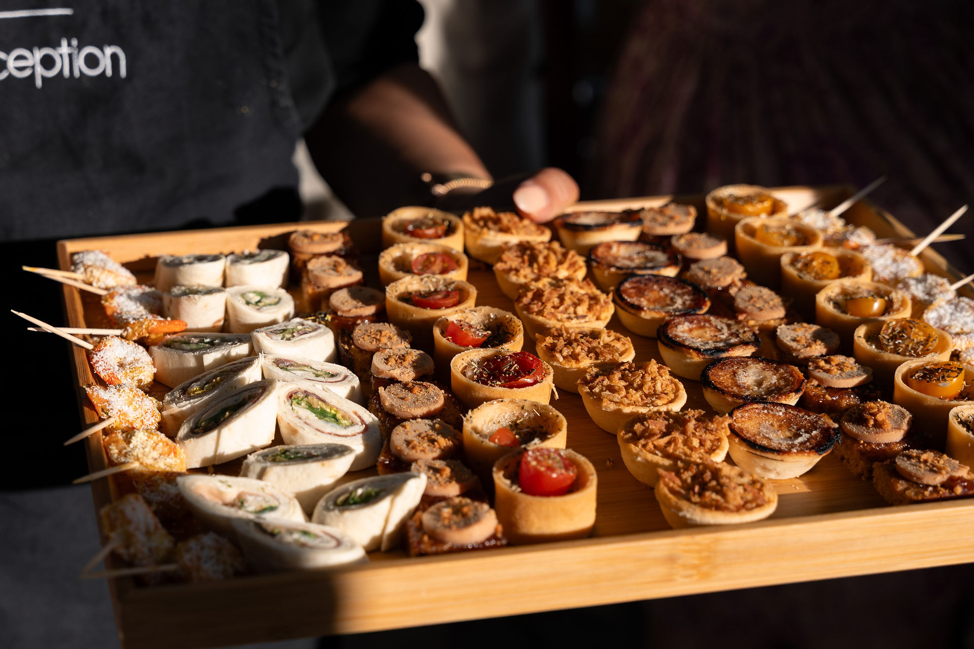 Zoom sur le plateau d'un traiteur pendant le cocktail du mariage avec une multitudes de proposition de petits fours