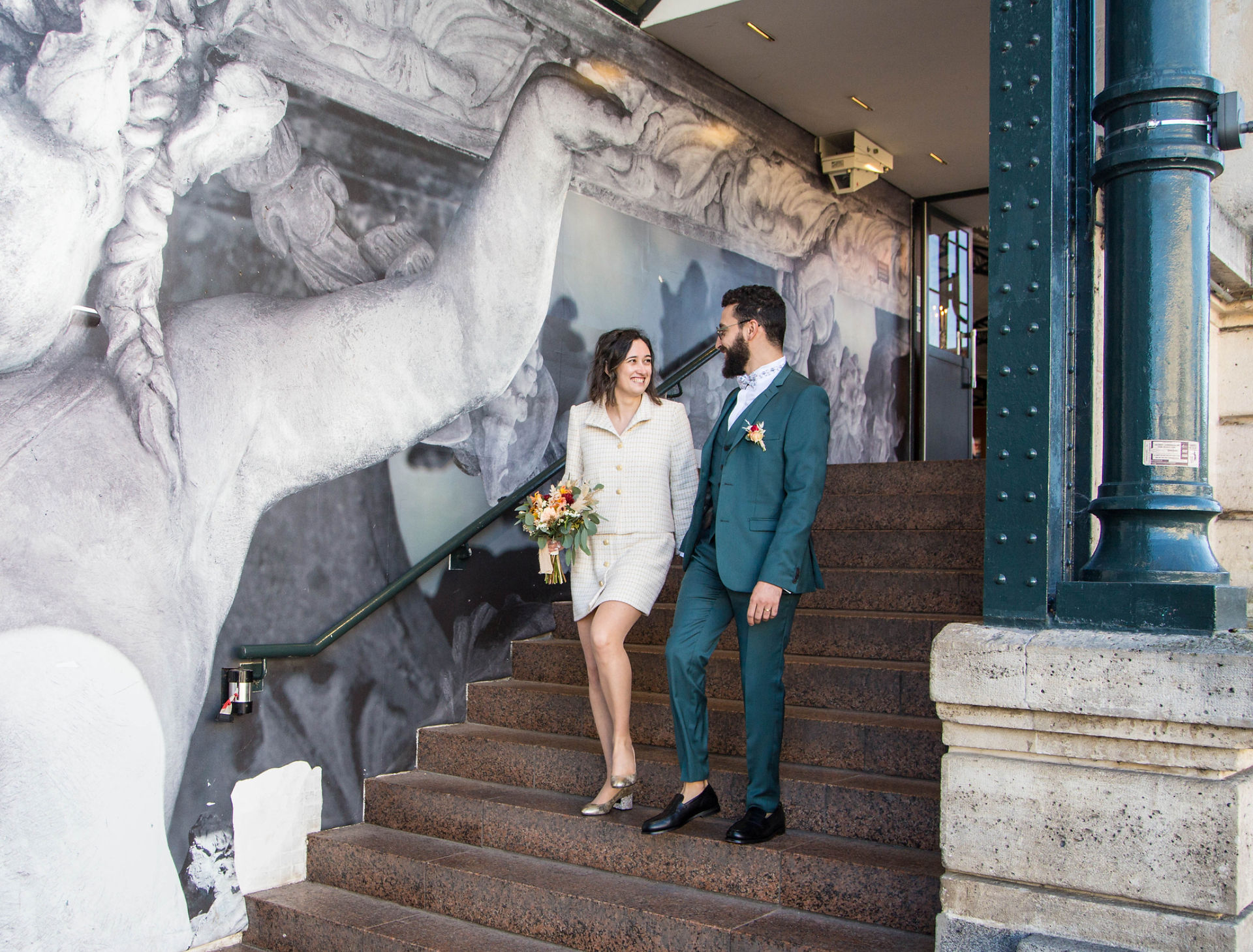 Mariés qui sont dans les escaliers, la mariée est en costume