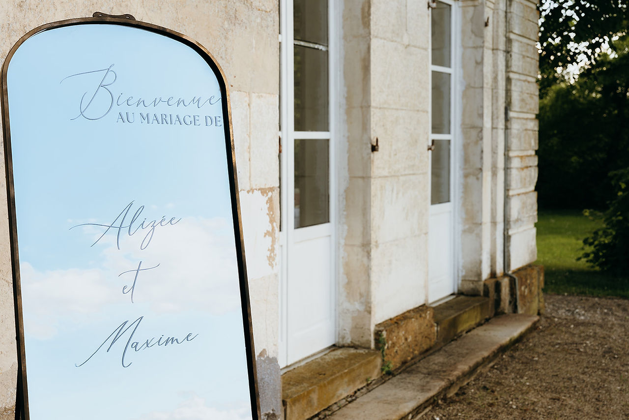 Zoom sur la personnalisation sur mesure d'un panneau de bienvenue d'un mariage, c'est un miroir long avec des petites moulures dorées