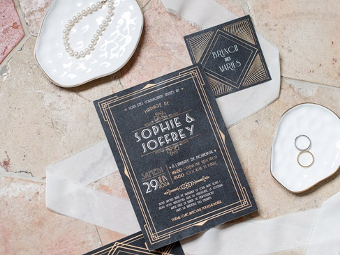 le faire-part, les alliance, l'invitation au brunch, et le collier de la mariée qui sont part terre pour faire une belle photo