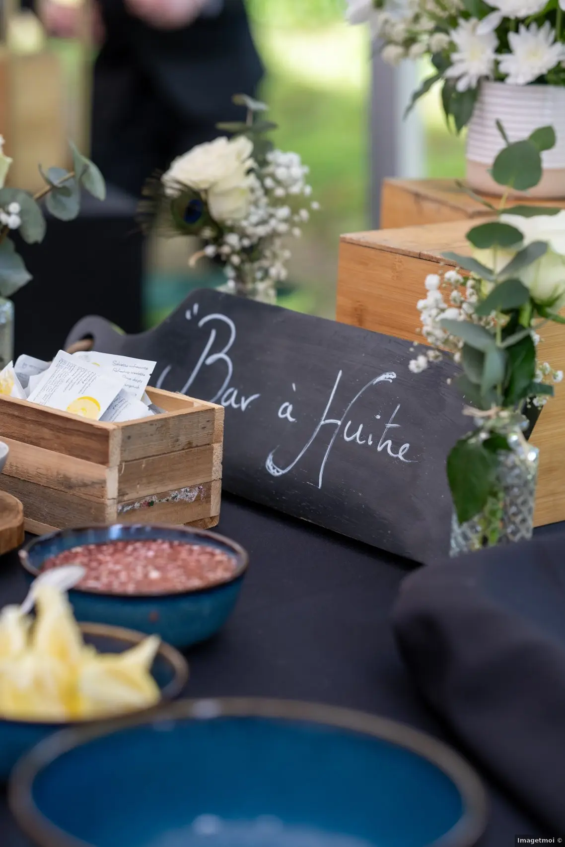Bar à huîtres lors du cocktail en extérieur d'un mariage avec une jolie décoration et un serviceveur qu'est derrière le stand pour accueillir les invités et les servir 