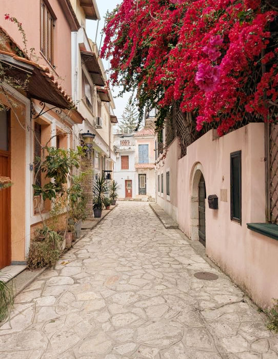 Narrow Greek alley with blooming bougainvillea and traditional houses