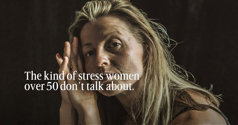 Thoughtful woman over 50 sitting quietly and reflecting, representing the hidden emotional stress many women carry after 50 and how accumulated stress affects mood, energy, sleep, and resilience over time.