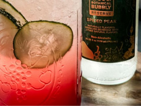 Functional mocktail for stress relief made with sparkling ingredients, cucumber slices, and ice in a bright kitchen setting representing calming wellness rituals for women over 50.