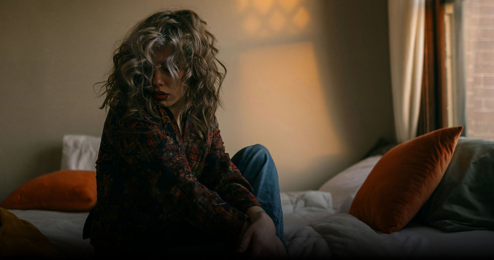 Featured image for “Exhaustion Is a Stress Signal” showing a woman sitting on the edge of a bed in dim morning light looking emotionally and physically depleted. The image represents chronic stress, burnout, nervous system exhaustion, waking up tired, adrenal-driven living, overwhelm, and feeling exhausted before the day even starts in midlife women.