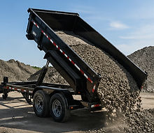 Dump trailer unloading gravel at construction site