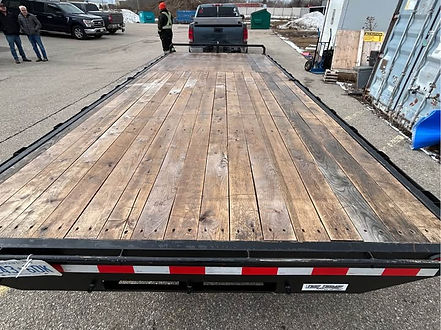 Deckover equipment trailer with wide flatbed for loading heavy machinery