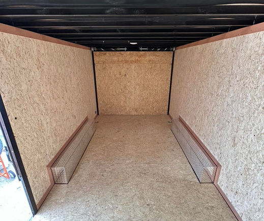 Interior of blackout enclosed trailer with plywood walls and LED lighting