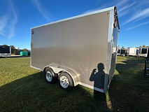 2027 Canadian Made 7x14 V-nose enclosed trailer featuring charcoal screwless siding, a rear ramp door, full tubular construction, 3,500 lb axles with brakes on both axles, and durable Drymax wall and floor panels.