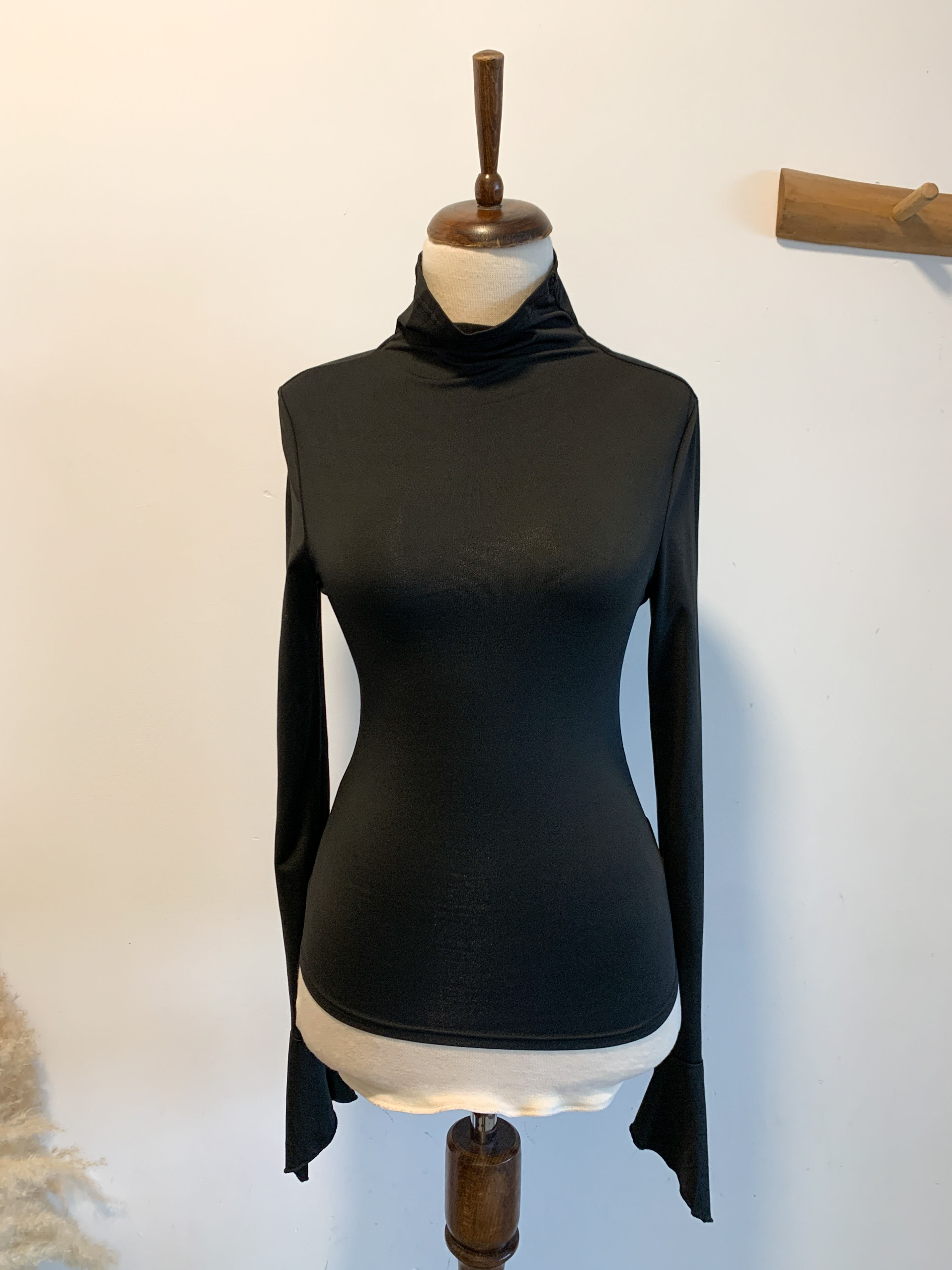 חולצה שחורה צווארון גבוה ושרוולים מתרחבים