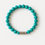 Thumbnail: Turquoise beaded bracelet with carved silver-colored metallic centerpiece on white background.