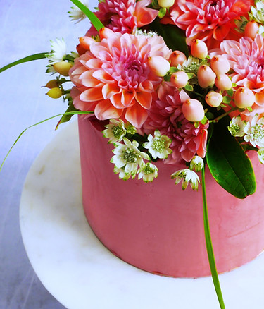 vegan buttercream cake in berry colour with matching flower arrangement