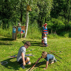 Eine Familie spielt das Riesen-Mikado-Spiel an einer Outdoor-Spielestation in Viehhofen