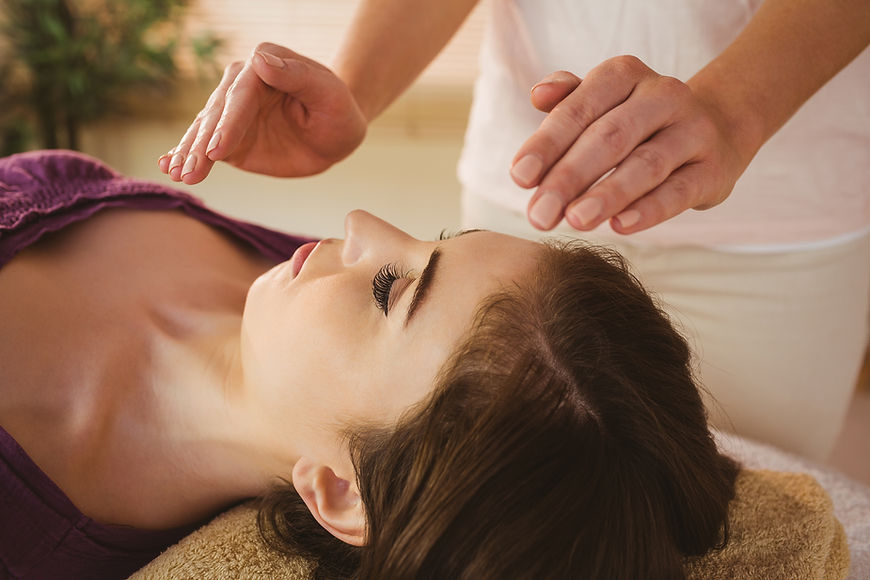 Young woman having a reiki treatment in therapy room.jpg