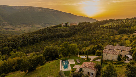 Sunset over a luxury villa in Umbria surrounded by hills and olive groves