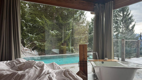 Luxury chalet bedroom with freestanding bathtub and forest view in Styria
