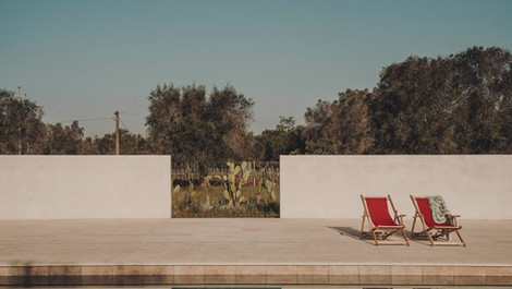 Sun loungers on a quiet terrace surrounded by Mediterranean greenery