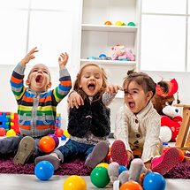 Toddlers playing with plastic balls.