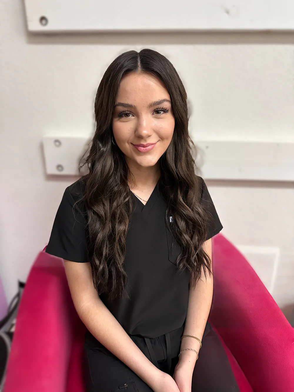 Friendly esthetician at Revive Spa seated in the studio, ready to help clients glow with custom skincare.
