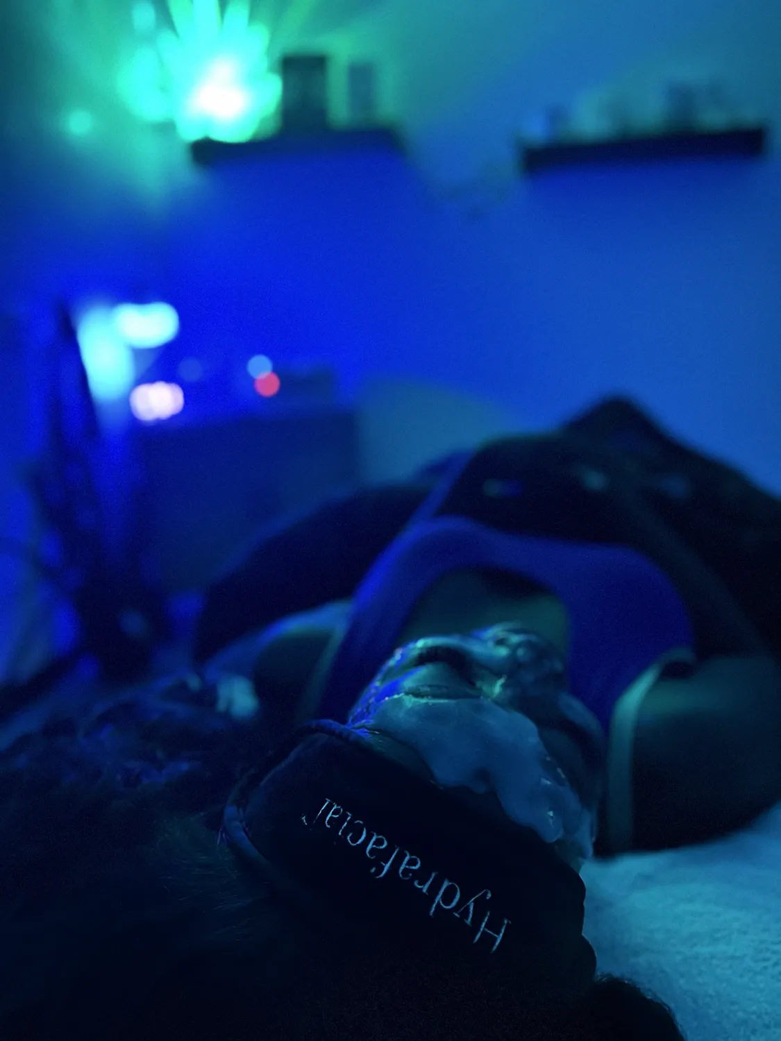Client relaxing under LED light therapy during a custom facial at Revive Spa & Lash Lounge, a top-rated Southern Pines spa.