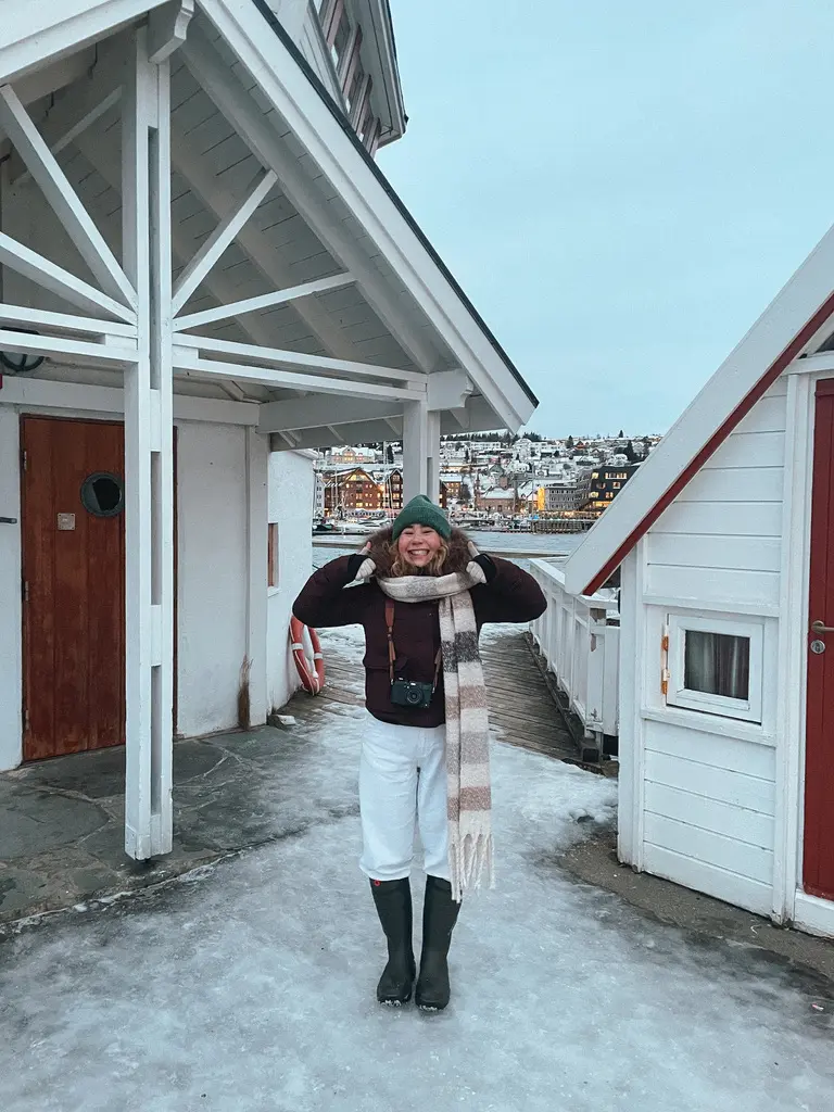 girl in snow boots with two thumbs up happy