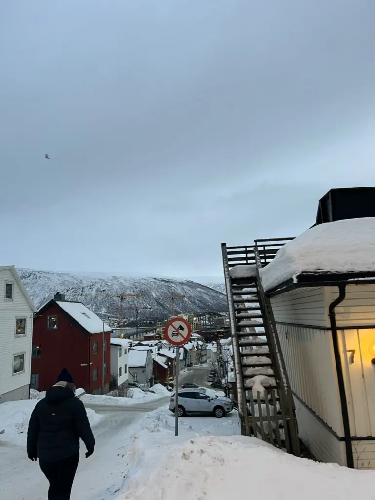 girl walking towards tromso town with lots of snow around her
