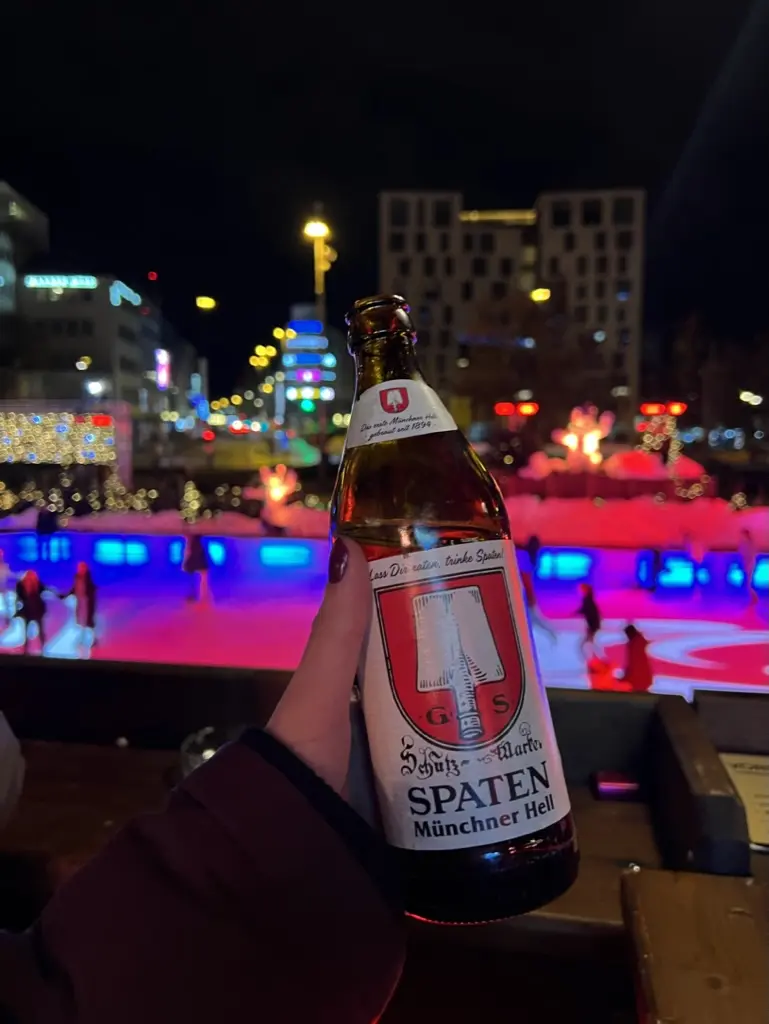 Beer at Germany Christmas Market with ice skaters in background