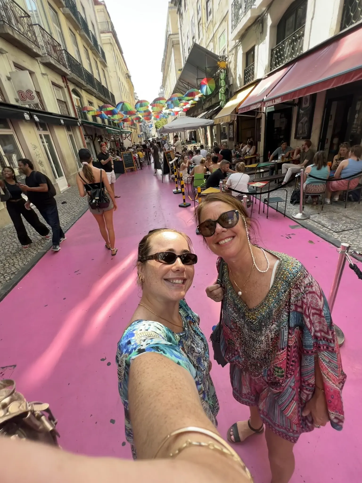 mother and daughter smiling on pink streets in lisbon