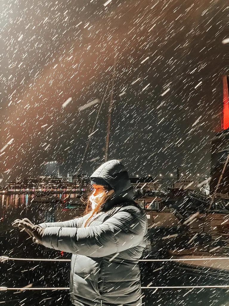 Girl standing with snow falling around her