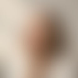 Woman over 50 gently touching her cheek, representing healthy mature skin after facial cleansing