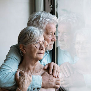 Pareja mayor mirando por la ventana, representando el miedo al Alzheimer y a perder la memoria y la autonomía