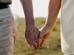 Manos de una pareja mayor caminando juntas al aire libre