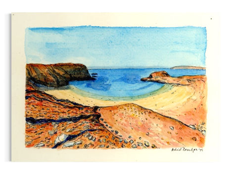 Op de afbeelding is op de voorgrond een hogere kustlijn te zien van een klei-achtige rode grond en stenen. In het midden is een strand te zien met een inham waar de zee begint. 