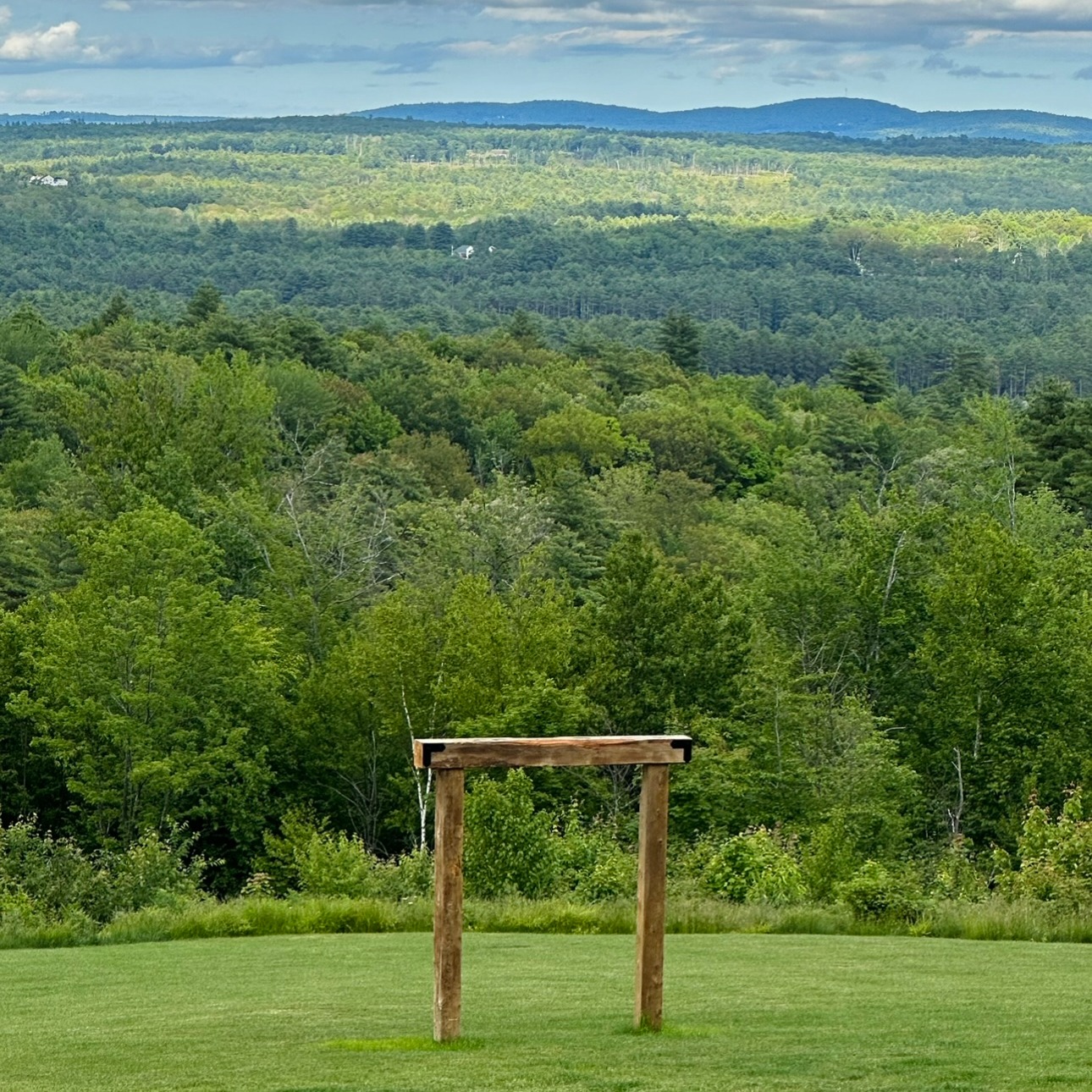 Hilltop ceremony site at Mountain View Stables with wooden benches, arbor and mountain views