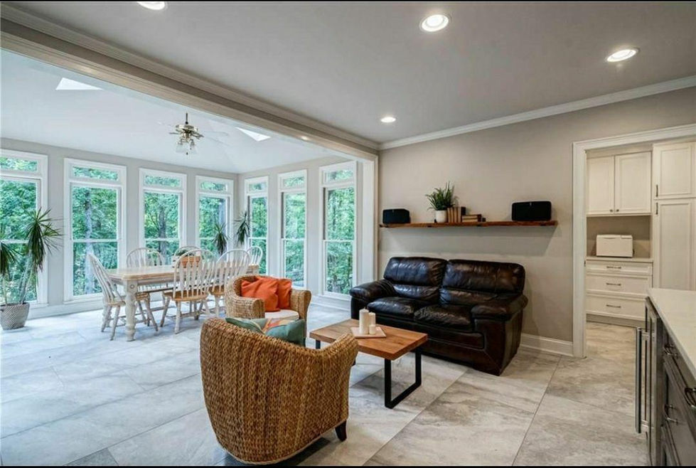 a living room with a couch wicker chairs and a table