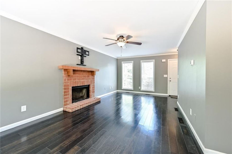 a living room with a fireplace and a ceiling fan