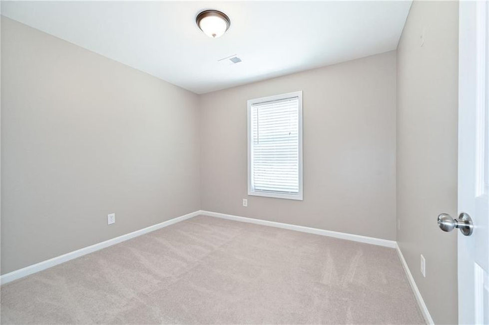 an empty bedroom with a window and blinds