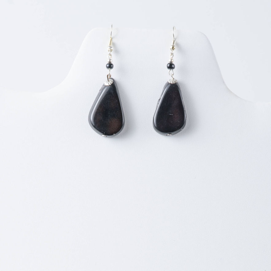 black teardrop tagua earrings on white display. lightweight, handcrafted, organic, natural fashion jewelry made from naturally sourced materials