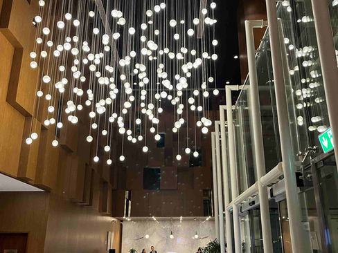 Die Lobby mit großen Kronleuchtern im Aleph Doha Residences, Curio Collection by Hilton