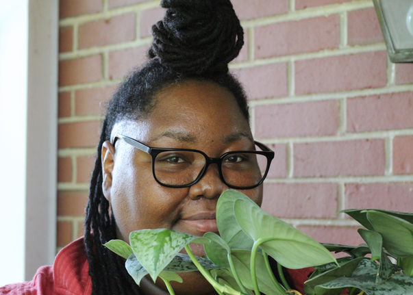 Beatrice holds a leafy satin pothos named Silver.
