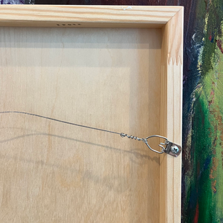the back of a painting on panel with hanging material, wire and hooks