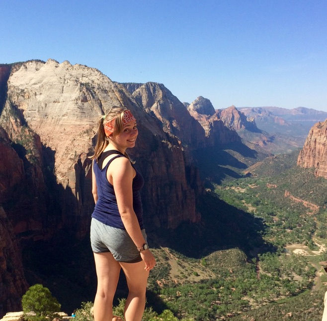 Jenna in Zion national park with the canyon below and beyond