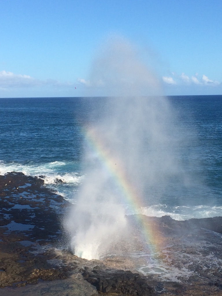 Water spraying from the ocean with a rainbow