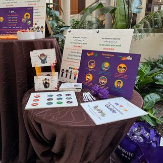 a table full of early childhood classroom materials including a feelings poster, stickers, and a workbook for families.