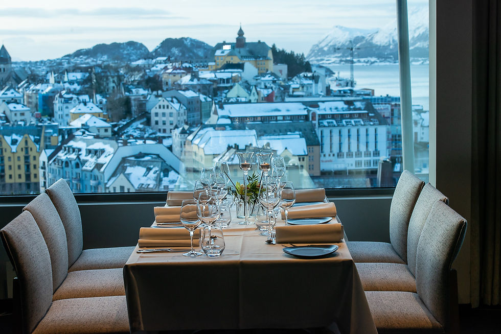 Dekket bord i restaurant med utsikt over Ålesund på vinteres