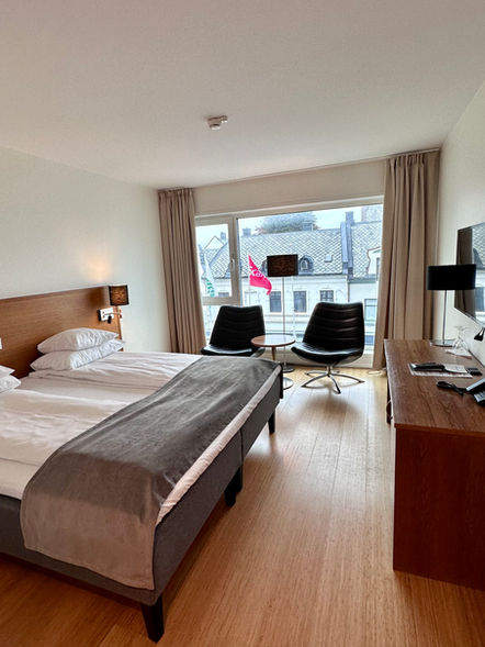hotellrom med dobbeltseng, kjøleskap og skrivebord.
