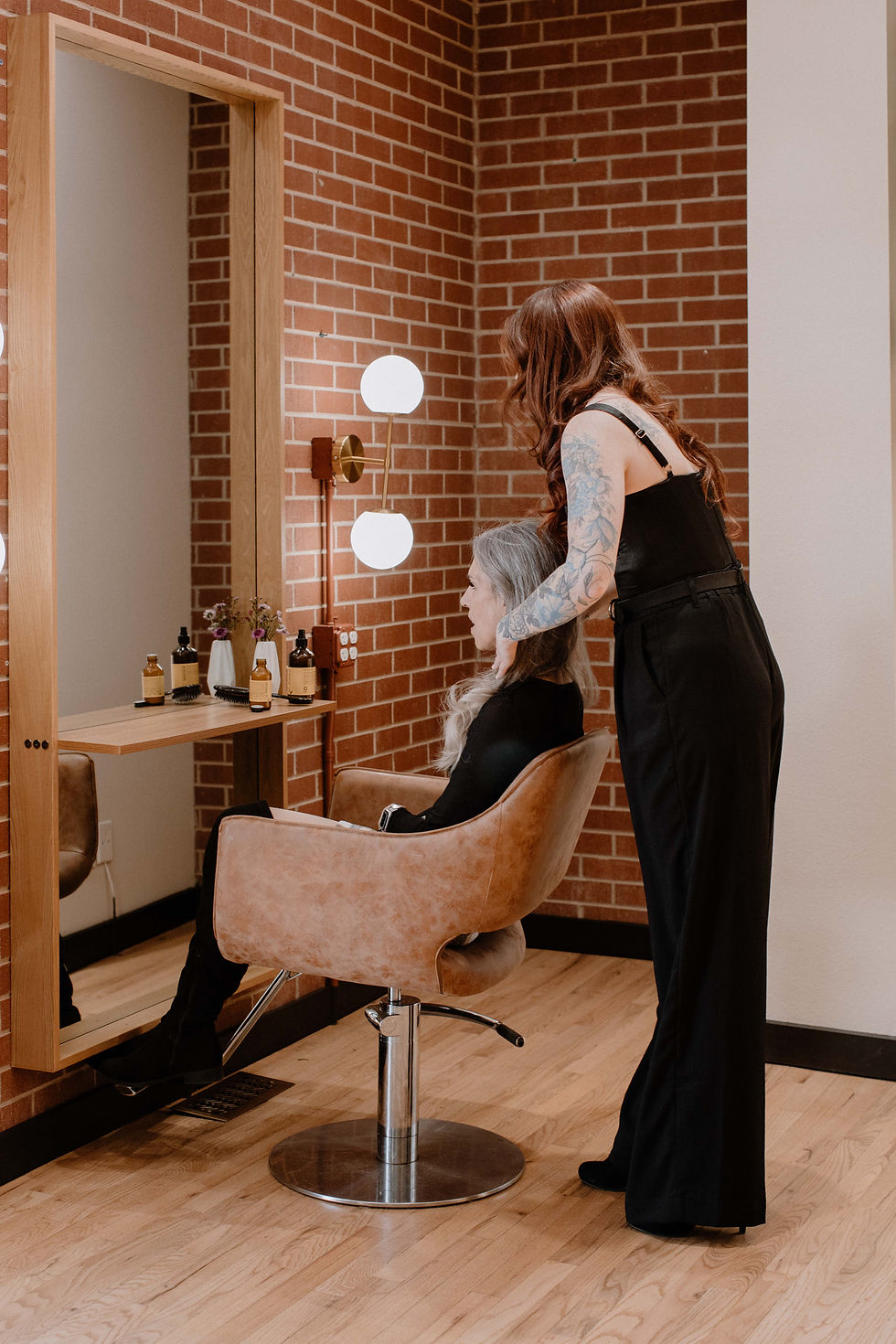 TRU Hair Salon stylist consulting a client about Colorado Springs hair extensions in a luxury salon setting