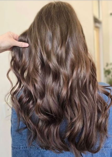 Glossy chocolate brown hair transformation at TRU Hair Salon Colorado Springs. Back view of long wavy brunette hair with dimensional shine and silky texture. Stylist showing off healthy, lustrous brown hair color with soft waves. Professional hair coloring services featuring rich mocha brunette with subtle dimension in Colorado Springs. Natural-looking brown hair with movement and depth.